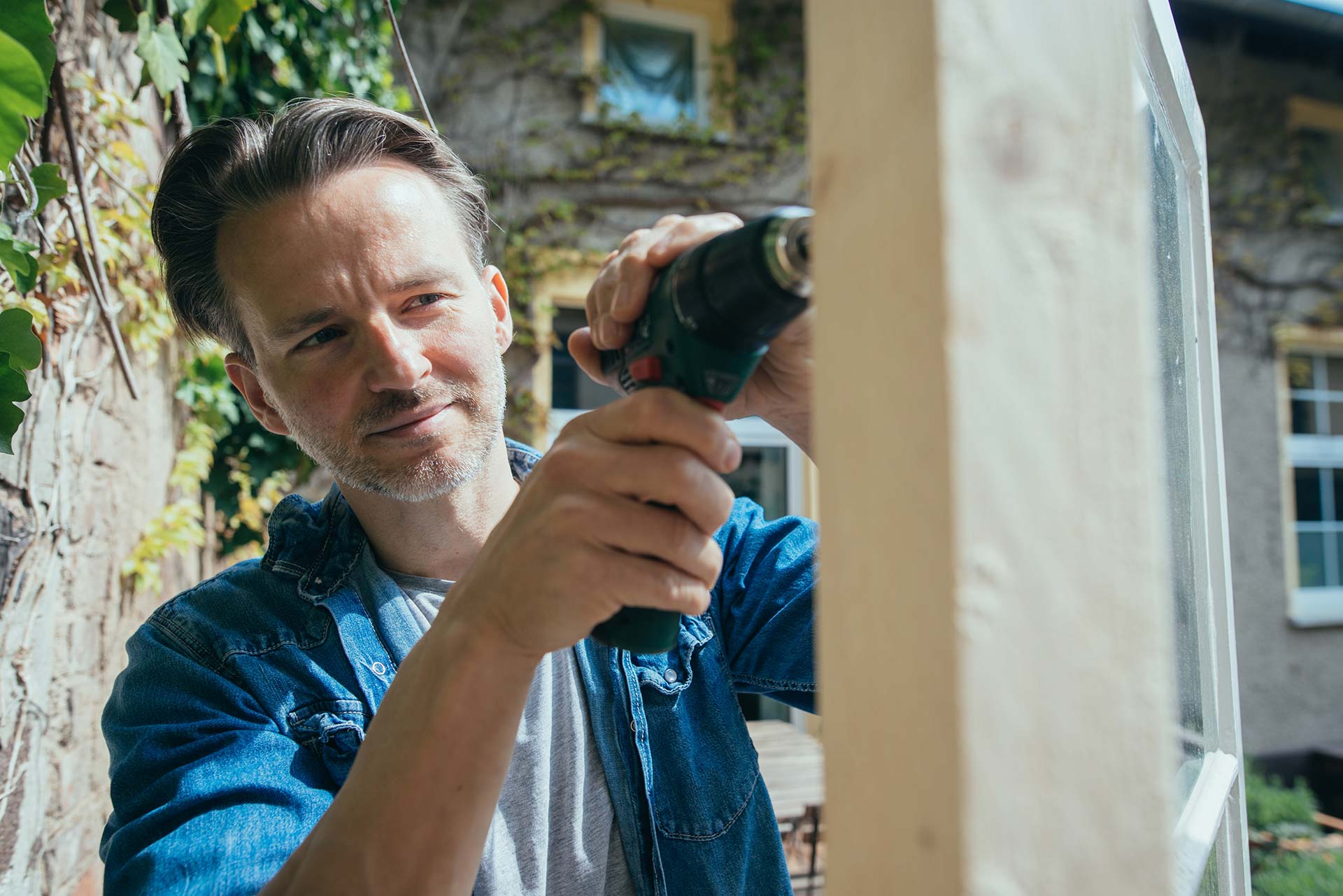 Mann baut mit Holz in seinem Garten