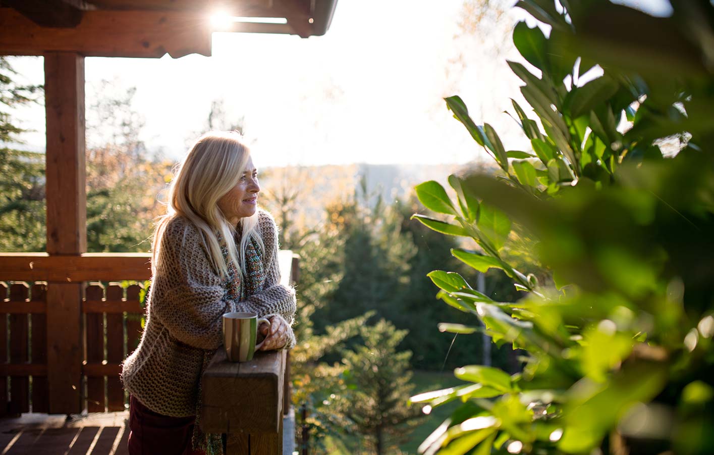 Frau auf Terrasse vom Massivholzhaus, Gartenhaus