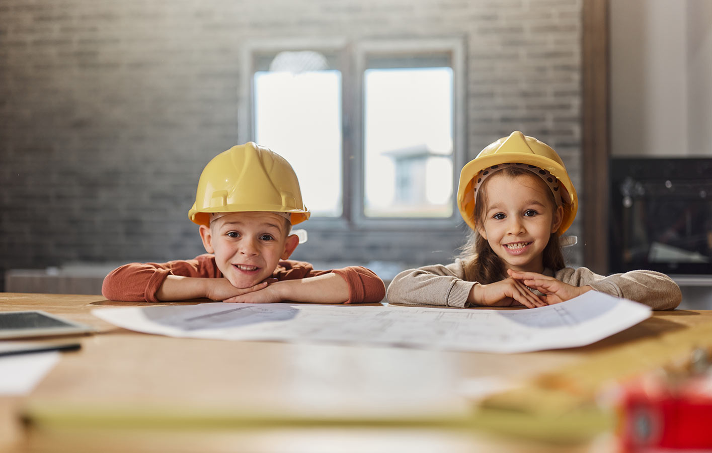 2 Kinder auf einer Baustelle mit Helm